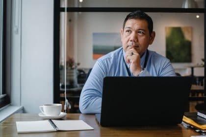 man_sitting_at_laptop_looking_to_make_a_decision