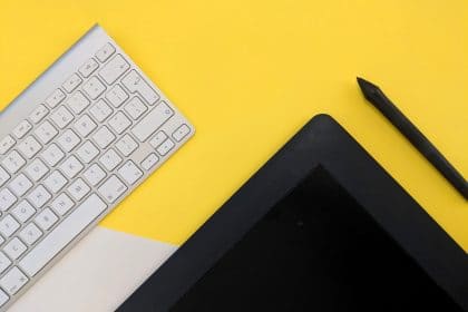mac keyboard with black tablet on yellow background