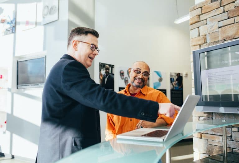 two men looking at laptop