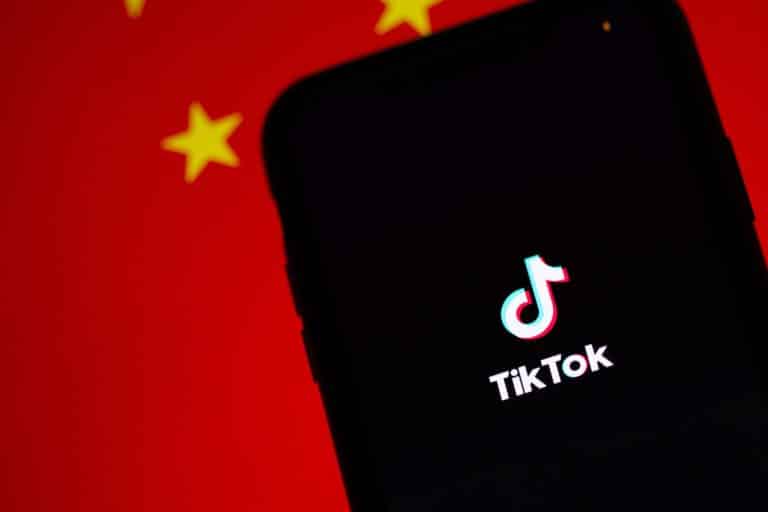red background with black phone and tiktok logo on the phone